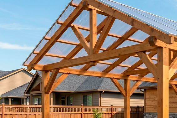 Zbliżenie na precyzyjną drewnianą więźbę dachową z przezroczystym pokryciem.